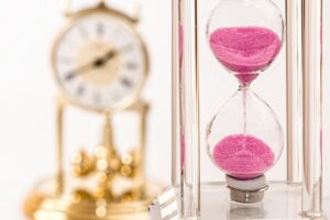 Hourglass on a table with soft light, symbolizing patience and time