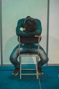 man slumped over in chair.