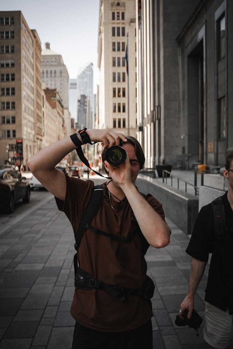 A photographer takes a photo in a city street.