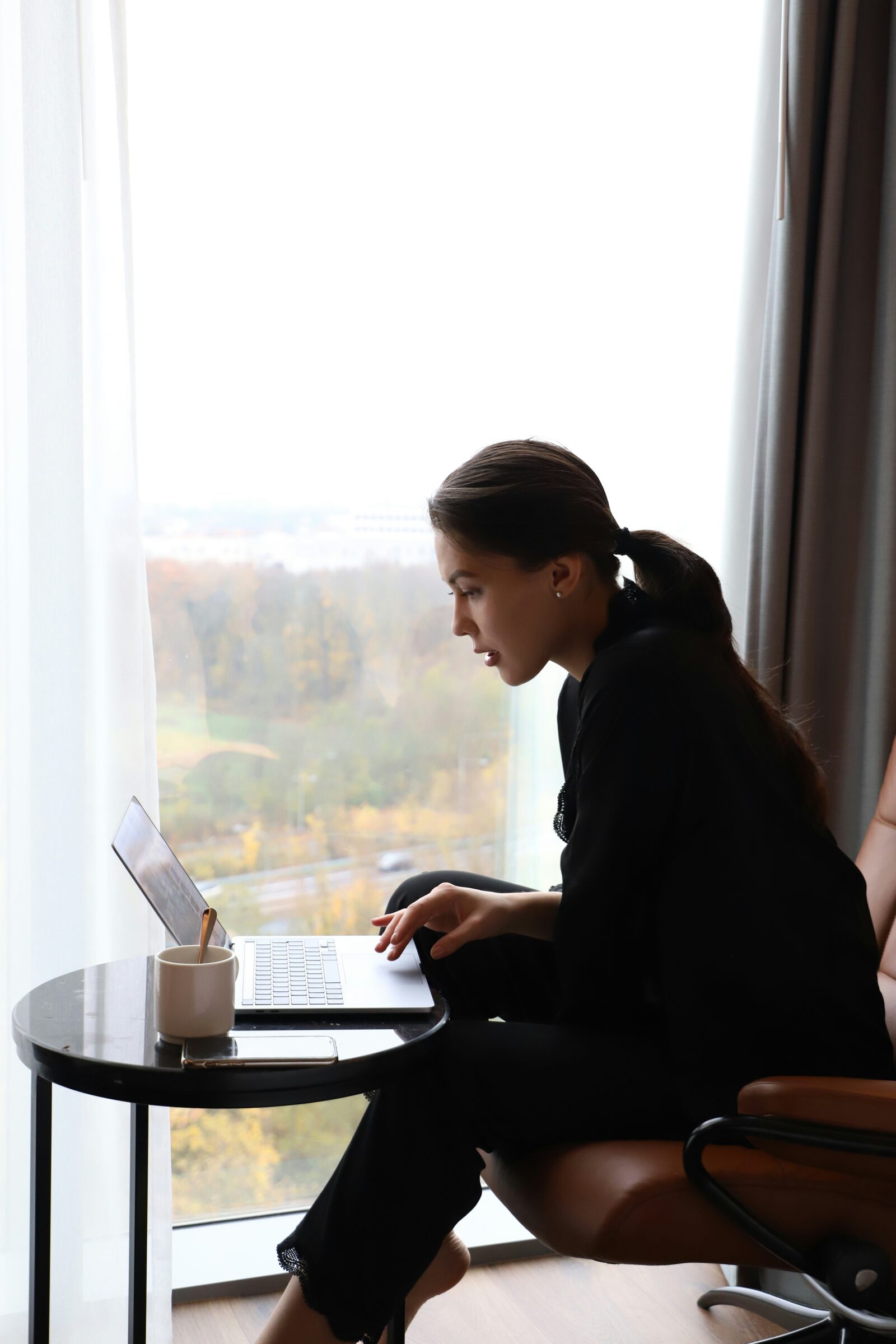 A person journaling in a calm setting, inviting reflection and support on a lap top coaching session