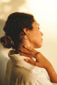 woman relaxed hands on sides of neck eyes closed in tune with self.