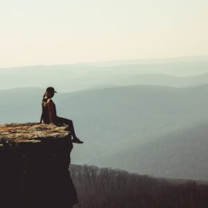 Woman facing the edge of a cliff, symbolising fear of decision consequences. Article on self-trust by Tess Rene Coaching.