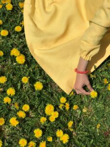 Joy in the sunshine and an example of a woman picking flowers who believes in herself and invests in what she values.