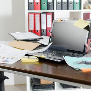 A cluttered desk with multiple papers symbolizing many different options going on For an Article on self-trust by Tess Rene Coaching.