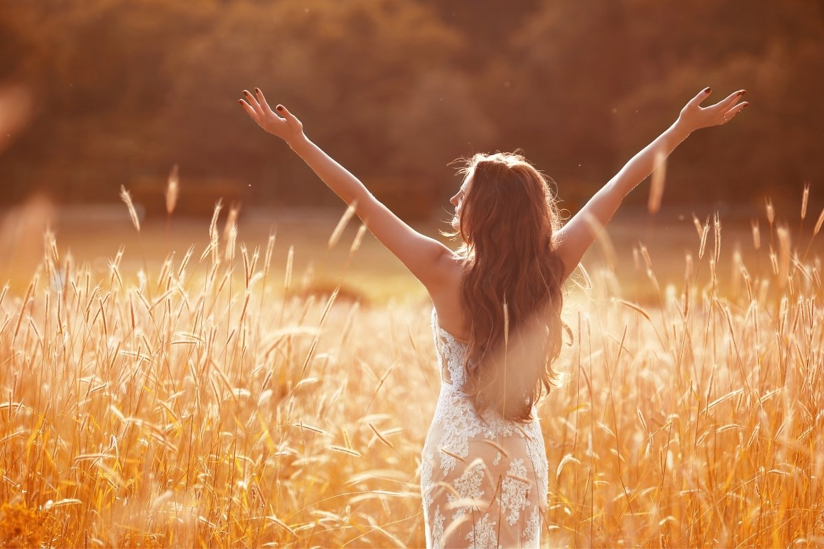 Woman standing open-armed in sunrise light, symbolising freedom and confidence, in cornerstone article on self-worth by Tess René Coaching.