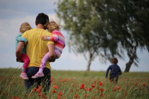 Family in flower field, representing emotional enmeshment and family roles, in an article by Tess Rene Coaching