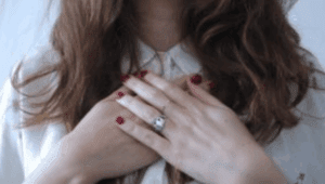 Hands placed gently on chest, illustrating the connection between indecision and self-trust, in article by Tess René Coaching.