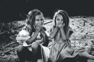 Two girls laughing together, symbolising connection through healthy limits, in an article by Tess Rene Coaching