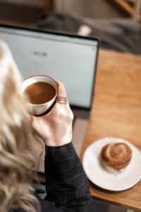 Woman holding a coffee cup, mindful first sip ritual, featured in a guide from Tess René Coaching.