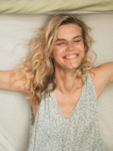 Smiling woman stretching freely, symbolising a new perspective on fear, in an article by Tess Rene Coaching.