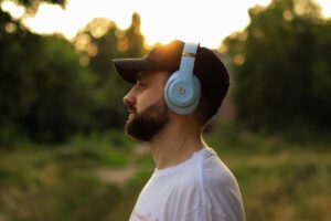 Man with headphones pausing from phone alerts in a Tess René Coaching article about distractions and calm.