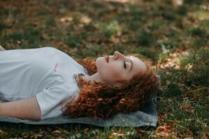 peaceful woman lying in nature in an article by Tess René Coaching
