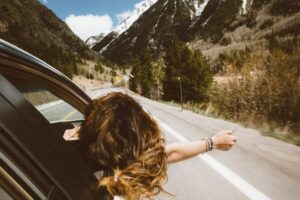 Woman leaning from car window in this Tess René Coaching article on methods to calm the mind.