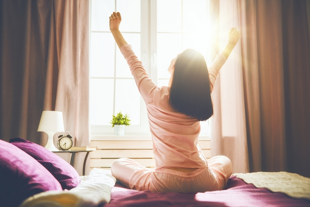 Woman stretching in morning sunlight, from an article on morning rituals for self esteem by Tess René Coaching