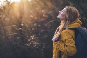 A woman pausing in sunlight during her morning walk, reflecting on making space for calm in an article by Tess René Coaching.