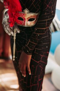 Close-up of a decorative mask with red feathers — a metaphor for how shame hides our true self.