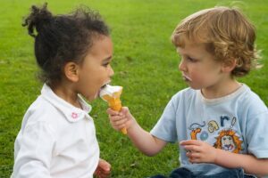 Two kids sharing an ice cream, showing the relief of honesty, from an article by Tess René Coaching.