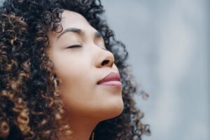 Woman with eyes closed and serene expression, symbolising inner steadiness in this Tess René Coaching article on how to manage emotions and build self-trust