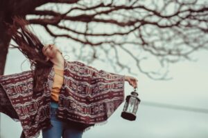 Woman standing outdoors with open arms and movement in this Tess René Coaching article about creating an empowered mindset