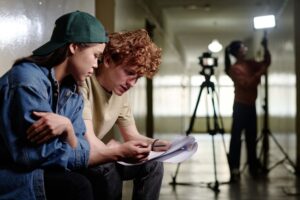 Two people sitting together reviewing notes, symbolising emotional awareness and problem-solving in this Tess René Coaching article