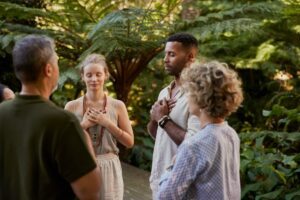 Group practising mindfulness outdoors, symbolising nervous-system regulation and connection, in article by Tess René Coaching about moving away from magnifying patterns of thoughts.