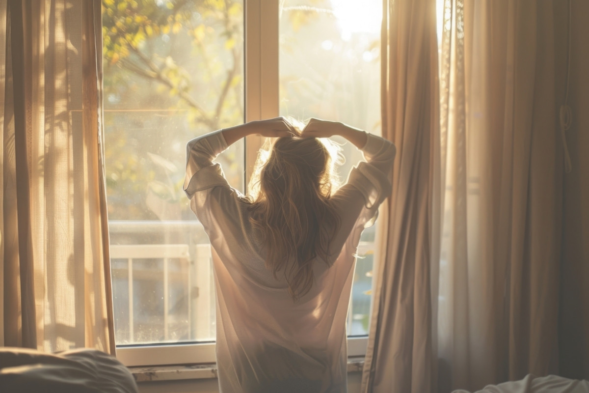 Woman relaxing in soft morning light, symbolising calm after anxious thoughts, featured in an article about how to stop catastrophizing by Tess René Coaching