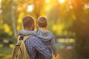in an article by Tess René Coaching about reparenting, a parent carries a child through warm sunlight