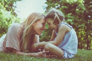 in Tess René Coaching’s article on reparenting, a mother and daughter laugh together outdoors.