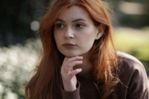 Woman reflecting quietly outdoors, symbolising healing disappointment through embodiment in an article by Tess René Coaching