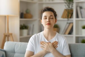 A woman practising the butterfly hug technique in this Tess René Coaching article about The Joy Reset free guide for finding calm and emotional balance.