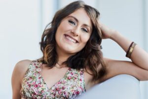 A woman smiling with soft confidence, included in a Tess René Coaching article about healing childhood emotional neglect.