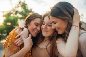 Friends embracing with soft smiles in a Tess Rene Coaching article on healing past hurts and opening the heart.