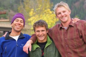 Three friends smiling with arms around each other shown in a Tess Rene Coaching article about the healing power of giving love