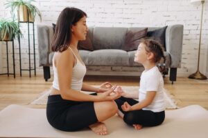 adult and child meditating together representing reparenting and healing the relationship with self in Tess René Coaching article