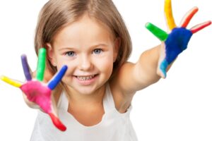 child showing colourful painted hands symbolising early patterns of self-expression discussed in this Tess René Coaching article