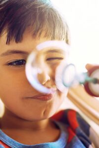 Child blowing bubbles representing curiosity and play in this Tess René Coaching article about the science of joy and nervous system healing