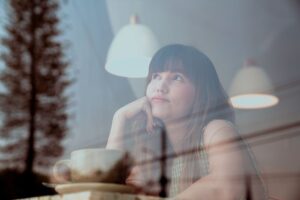 woman looking out window discouraged from nervous system activation during decision making in a Tess René Coaching article