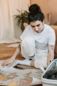 Woman studying a map in this Tess René Coaching article about knowing when to keep going or change directions on the path to achievement.