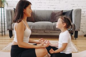 An adult and child sitting face to face in meditation, featured in this Tess René Coaching article on inner child support during emotional flashbacks.