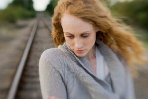 emotional avoidance in friendships, a woman looking down outdoors, in a Tess Renè Coaching article