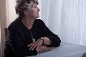 friendship loss confusion, an older woman looking out a window, in this Tess Renè Coaching article