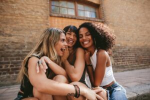 misconceptions about good friendships, friends laughing together, shown in a Tess Renè Coaching article
