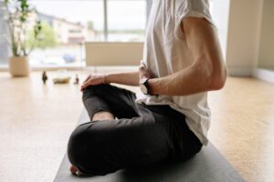 Man seated with hand on belly building emotional capacity in this Tess René Coaching article on control your feelings