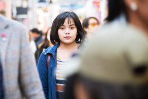 difficulty relating to your emotions, a woman standing alone in a crowd, in this Tess Renè Coaching article