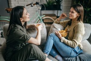 self abandonment in friendships, two friends talking comfortably on a sofa, in this Tess Renè Coaching article