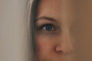 Closeup of a tired eye and face, shown in this Tess René Coaching article about helping others too much