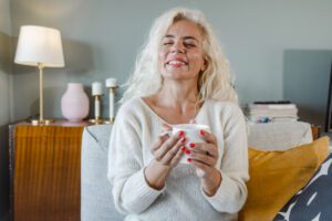 In this Tess René Coaching article, a relaxed woman holding a mug reflects self acceptance and secure love.