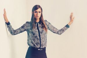 woman standing with arms extended against walls in this Tess René Coaching article about taking up space and holding boundaries and saying no.