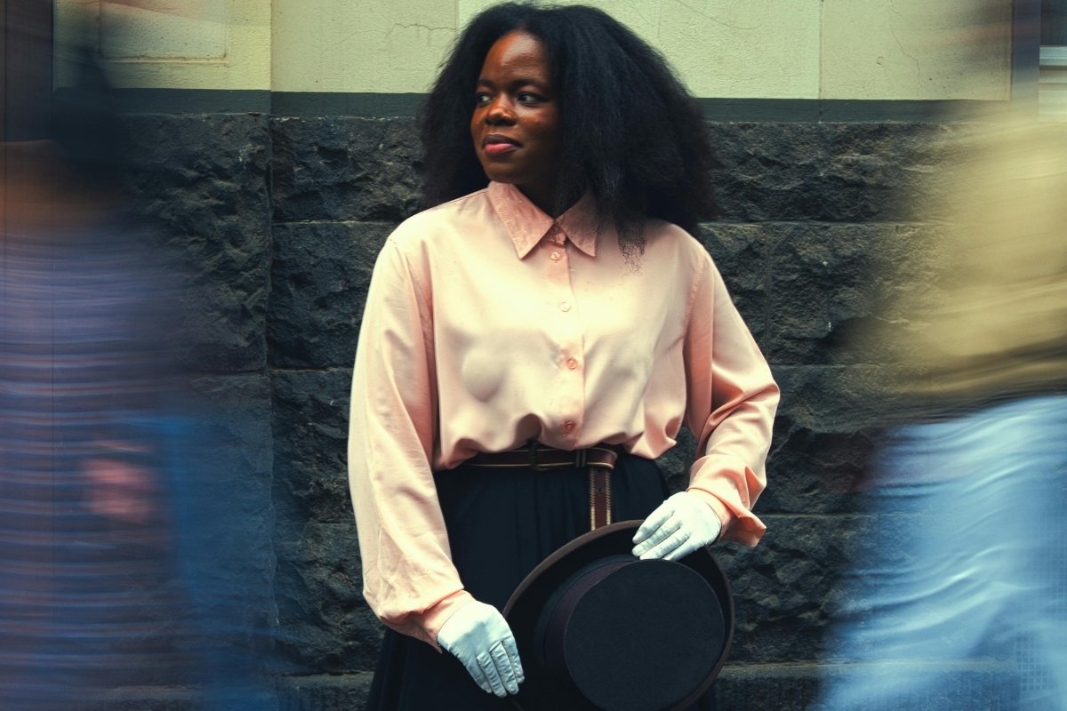 woman standing calmly while people move around her in motion blur, representing staying grounded amid worry in this Tess René Coaching article
