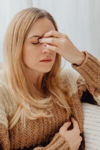 Woman sitting with emotional overwhelm in this Tess René Coaching article about fear of boundaries, people pleasing, emotional shutdown, and relationship anxiety rooted in childhood wounds